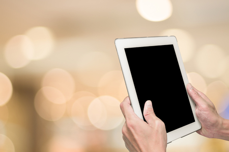 One using white tablet pc and abstract blur warm light in backgroundの写真素材