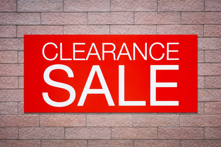 Red clearance sale billboard on brick wallの写真素材
