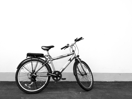 Bicycle parking on asphalt concrete road and white wall in the background - black and white filterの写真素材