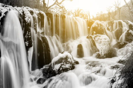 Frozen water fall in spring season - Jiuzhaigou, China. Sunlight shining from behind.の写真素材
