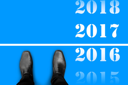 Black shoes standing at the line between last year 2016 and happy new year 2017の写真素材