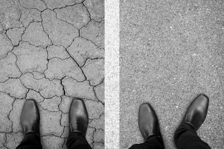 Two businessman standing on the different path. One relaxing on smooth flat path, another one feeling pressure on damaged path. Easy and hard. Business and life are not fair.の写真素材