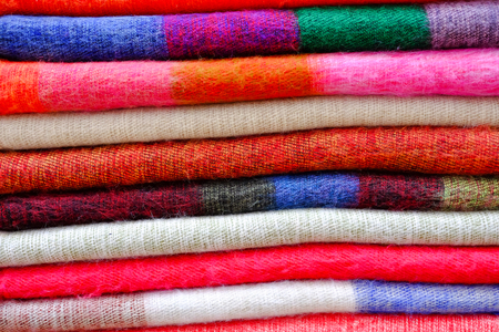 Colorful knitting wool fabric scarf folded and stacked together in a row for background.の写真素材
