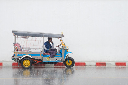 Bangkok, Thailand - November 19, 2017 : Tuk tuk taxi waiting for customer under the rain near Grand Palace.のeditorial素材