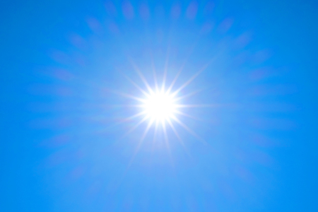 The sun shining light in blue sky in summer as background.の写真素材