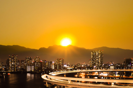 Sunrise and sunset over the mountain behind big city.の写真素材