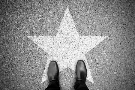 Business concept. Businessman standing on the street and star sign on the floor.の写真素材