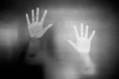 Shadow of man on the white frosted glass representing dangerous, fear, help, haunting, horror and scary.の写真素材