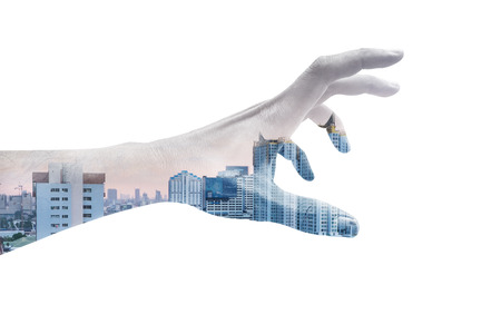 Double exposure hand reaching out and city view in evening light representing struggling urban life concept.の写真素材