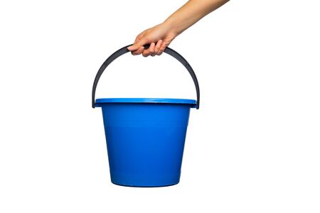 Plastic blue water bucket with black handle in hand. Cleaning Products and Supplies. Isolated white backgroundの写真素材