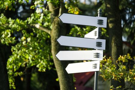 information. iron white blank direction indicator closeup on blurred background with trees. mockup