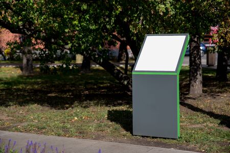 grey green empty information booth on the background of the Park in the summer. mockupの写真素材