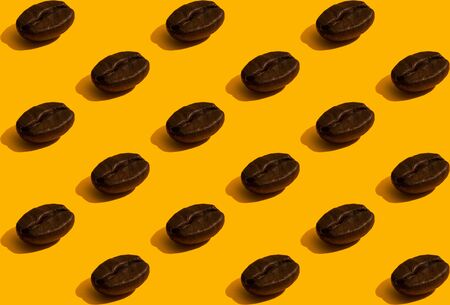 Lots of coffee beans stacked in rows. Seamless pattern in a minimalistic style on an orange backgroundの写真素材