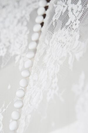 Details of the bride's dress close-up buttons at the back. The concept of wedding traditions