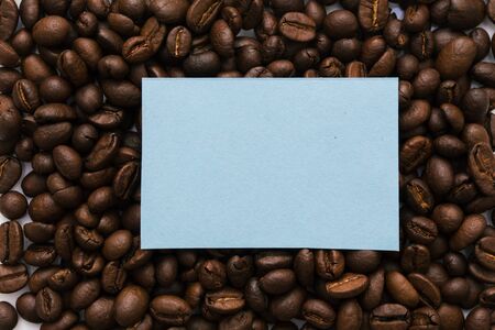 Mockup of a blue note on a solid background of many coffee beans. Copy space for textの写真素材