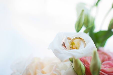 Wedding rings of the bride and groom on the background of a bouquet. Wedding conceptの写真素材