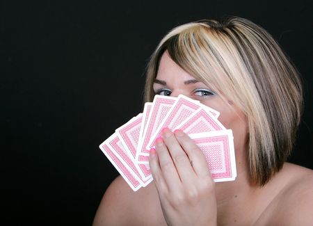 a young woman holding cards hiding her poker faceのeditorial素材