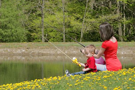 a woman and her young boy child go fishing at the pondの写真素材