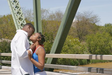 African American couple kissing on a bridgeの写真素材