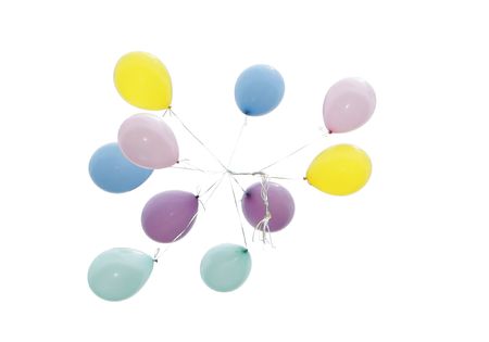 ten multicolored helium balloons floating away into the skyの写真素材