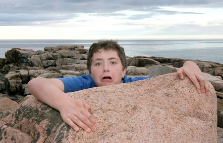 a young boy child falling off a rock on the coastの写真素材