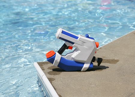 a white and blue squirt gun next to a poolの写真素材