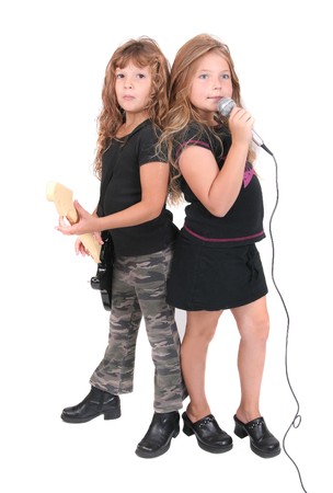 two young female childred playing guitar and singing like rockstars over whiteの写真素材