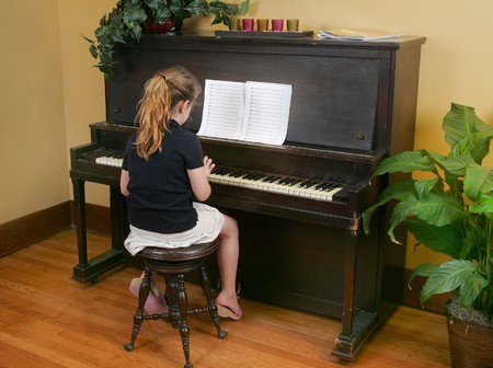 one yougn child playing piano with sheet musicの写真素材