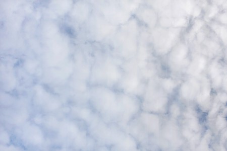 bright blue sky behind interesting puffy white cloudsの写真素材