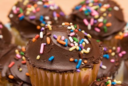 large group of chocolate frosted cupcakes on a plate closeup tight cropの写真素材