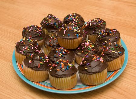 large group of chocolate frosted cupcakes on a plate closeup tight cropの写真素材