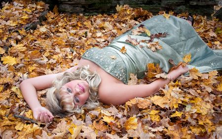 young teen blonde girl in a prom dress outdoors with fall colorsの写真素材