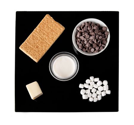 ingredients for s'mores truffle candy on a black plate including graham crackers, chocolate chips and mini marshmallowsの写真素材