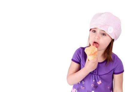 young caucasian girl eating ice cream orange sherbet against a white backgroundの写真素材