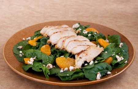 one plate of mandarin orange chicken salad with feta cheese over a bed of spinachの写真素材
