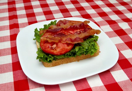 bacon, lettuce and tomato on a white plate over traditional tablecloth. building a blt sandwich 4 of 5の写真素材