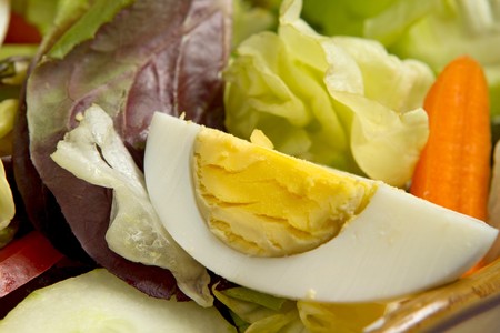 quartered egg in a green salad closeupの写真素材