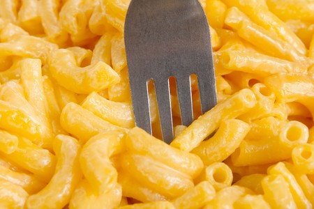 macaroni and cheese dinner on a yellow plate isolated over whiteの写真素材