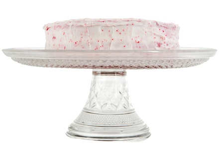 red velvet cake with pink frosting on a serving tray isolated over whiteの写真素材