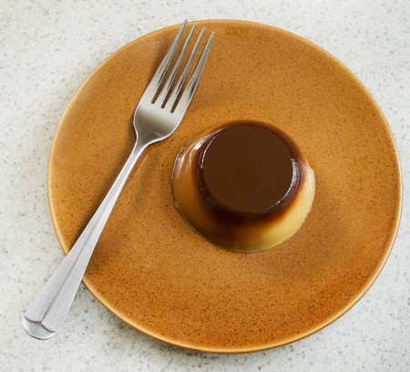 one small caramel flan dessert on a plate