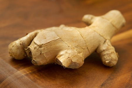 one piece of ginger root closeup on wood