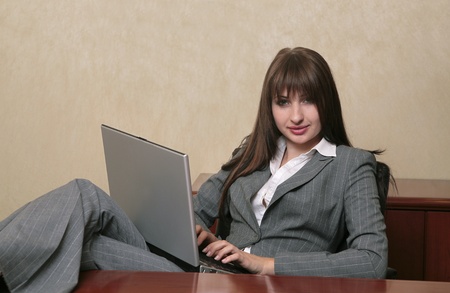 twenties brunette professional typing on a laptop computerの写真素材
