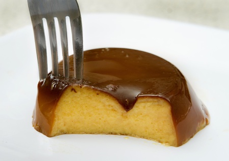 small caramel flan with a bite removedの写真素材