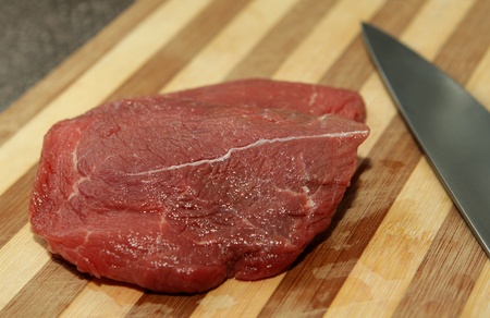 steak fillet on a cutting board with a knife closeupの写真素材