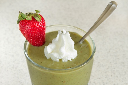 kiwi fruit smoothie with whipped cream and a fresh strawberryの写真素材