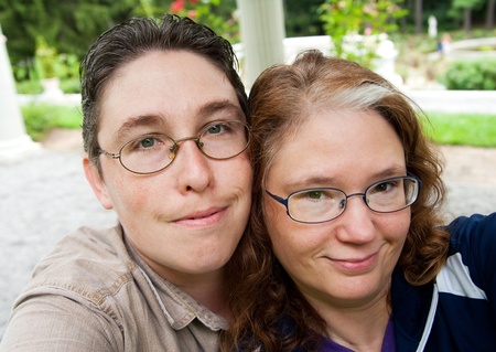 one guy and woman taking their own self portrait in a parkの写真素材