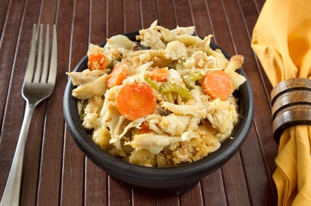 bowl of chicken noodle soup casserole with fork and napkinの写真素材