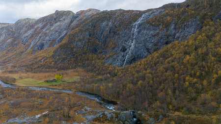 Waterfall Cascading Down Rocky Cliff in Autumnの写真素材