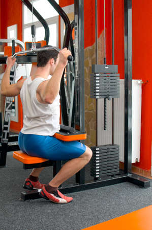 Full body of a man at the gym lifting weights on the windlass