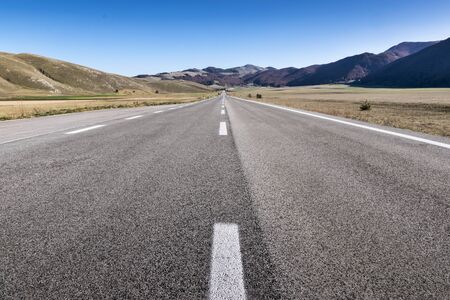 Long straight road on asphalt on mountain plateau